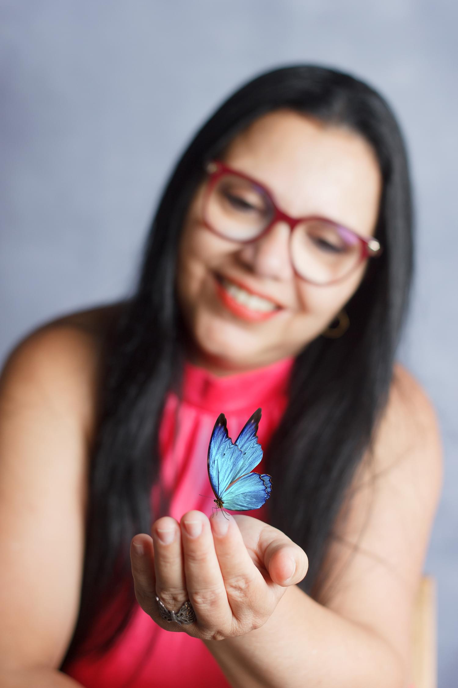 Julia Telles segurando uma borboleta azul