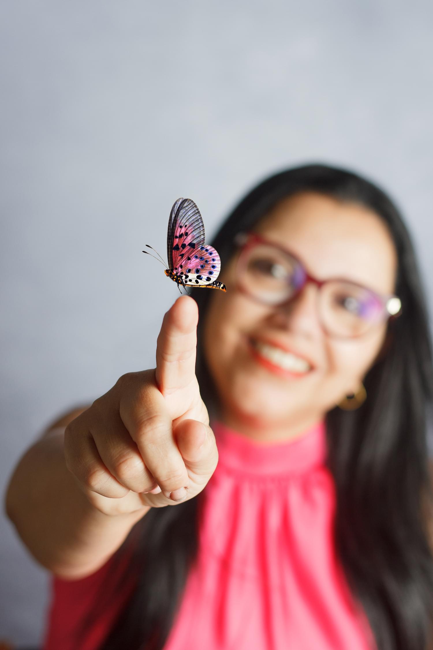Julia Telles segurando uma borboleta de asas rosa
